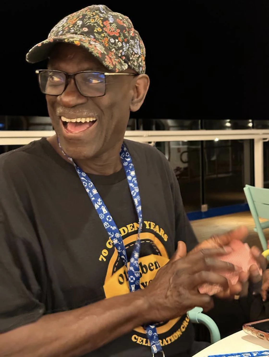 Our founder smiling, wearing glasses and a floral cap